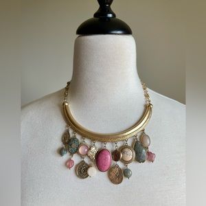 Gold tone necklace with stones in multi shades of pinks and gray.